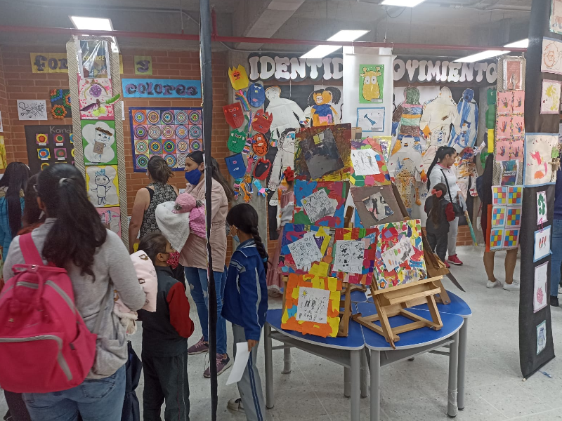 Estudiantes y padres de familia visitando uno de los salones de exhibición de muestras artísticas