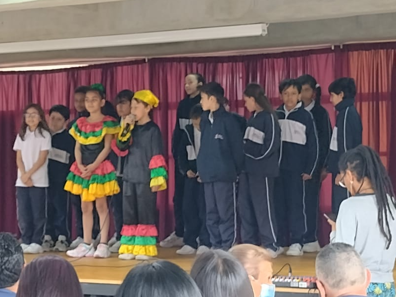 Estudiantes sobre el escenario realizando baile típico colombiano