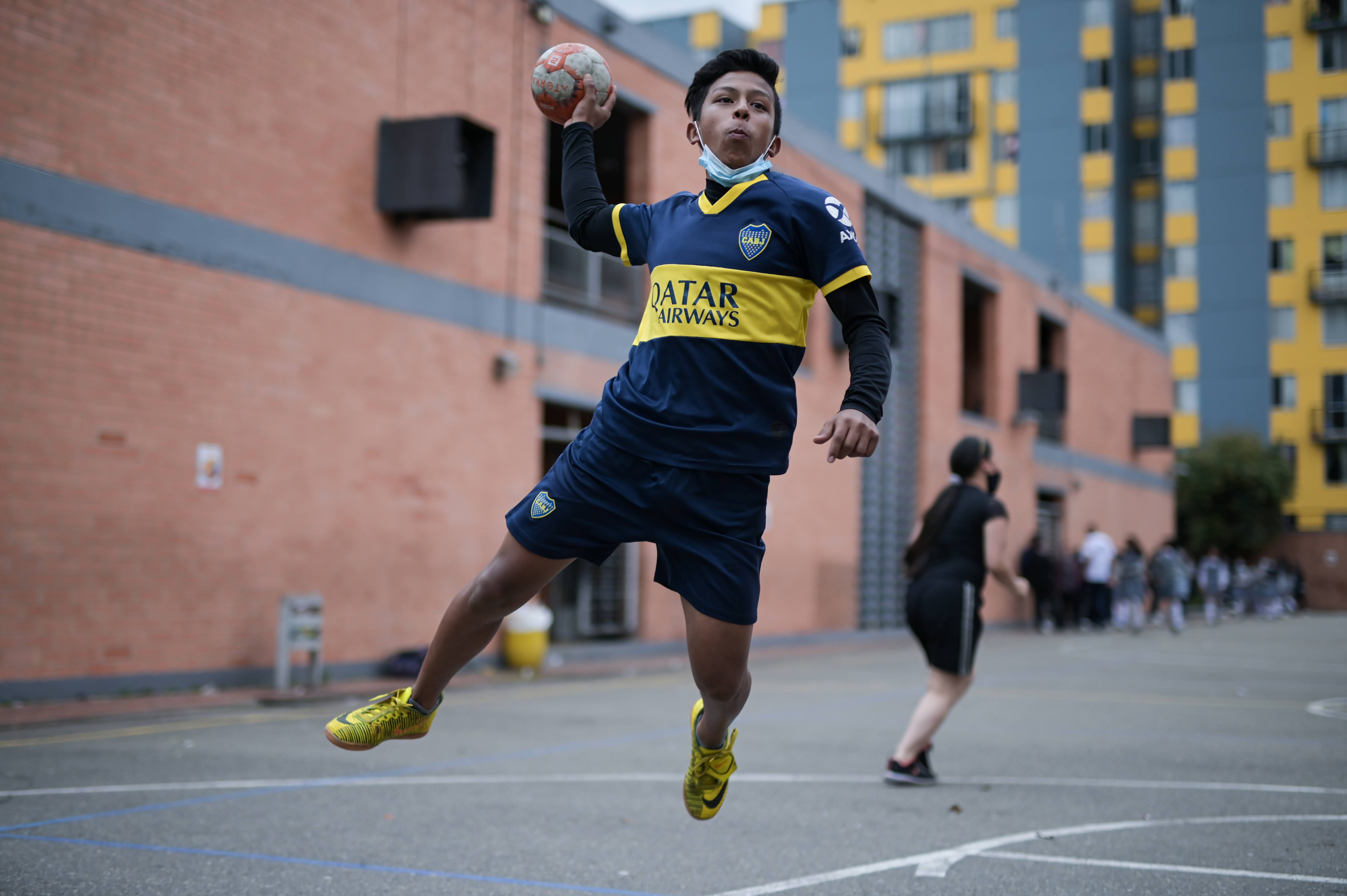 Estudiante jugando balon-mano