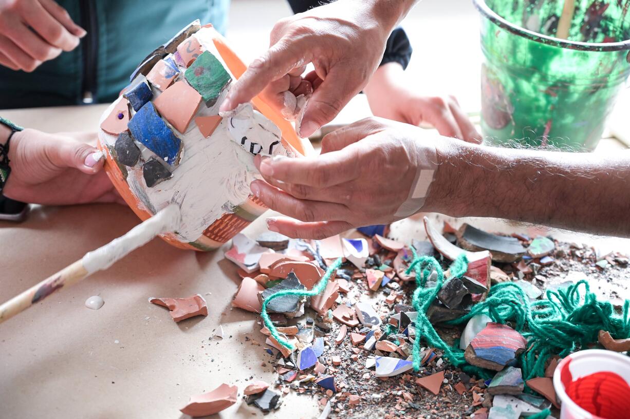 Manos reconstruyendo trozos de cerámica