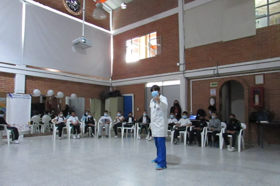 Persona exponiendo en auditorio el libro zoomos