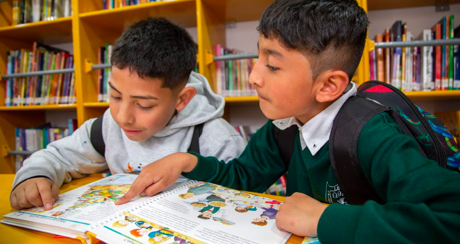 Niños observando libro en BiblioBus