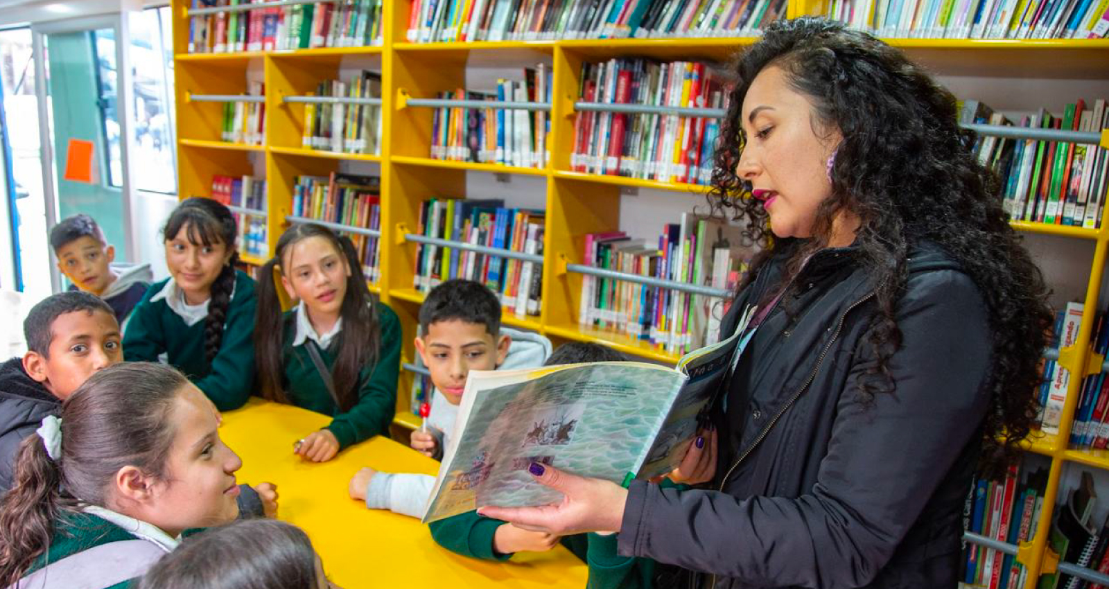 Niños observando libro en BiblioBus
