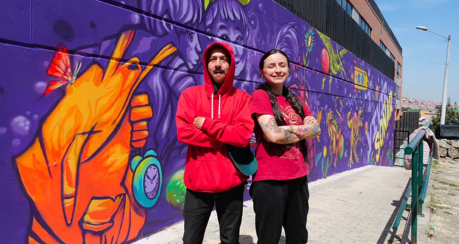 Muralistas con su obra en colegio