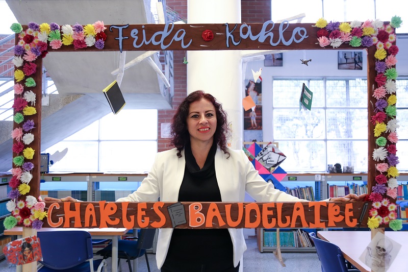 La profesora Aidé sosteniendo un marco