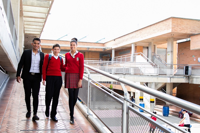 Tres estudiantes caminando en el colegio
