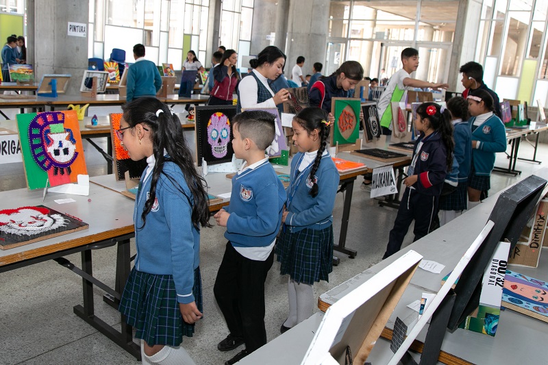 Niños viendo la exposición de tejidos