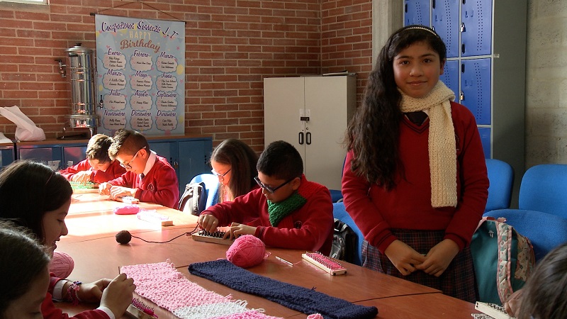 Niños en un salón y una niña de pie