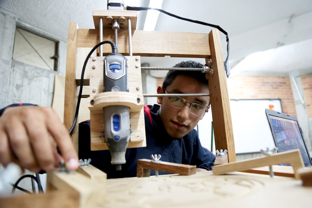 Un estudiante con una maquina de madera