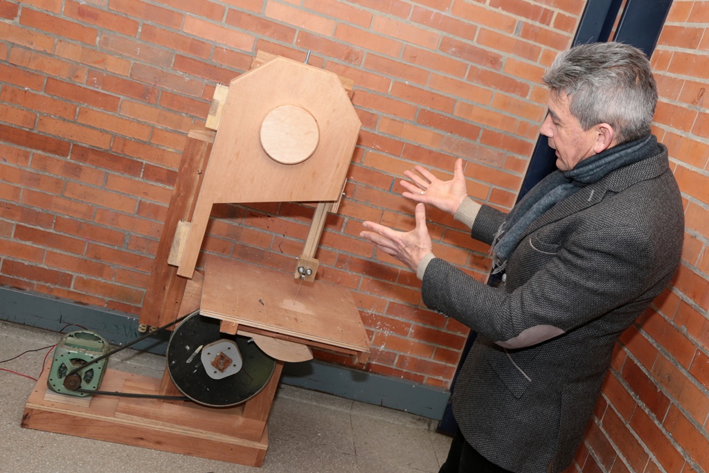 EL profe Hugo con una maquina de madera
