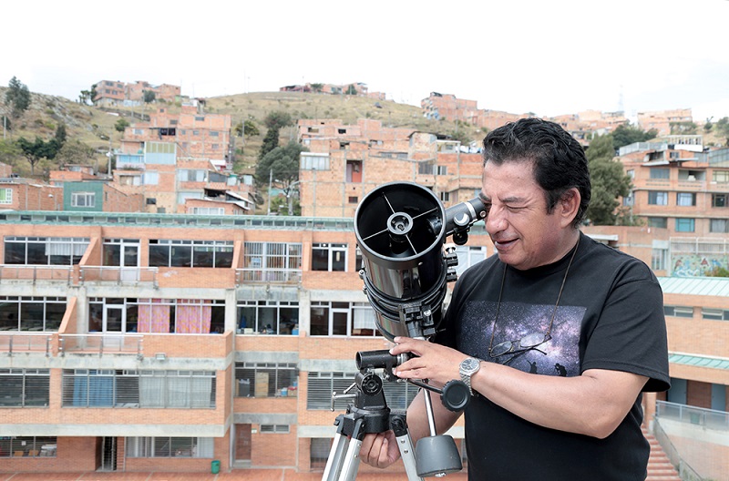 Profesor mirando en un telescopio