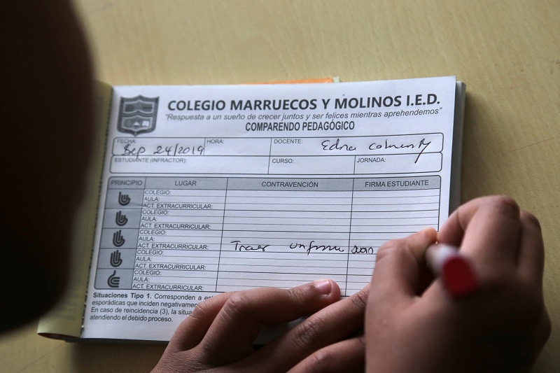 Niña escribiendo un comparendo