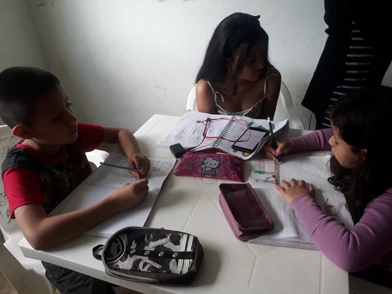 Tres niños estudiando en un celular