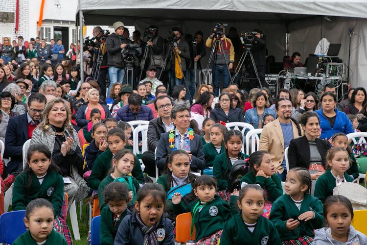 Claudia López sentada con estudiantes